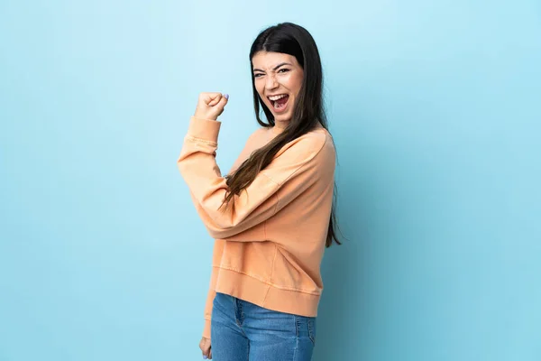 Joven Morena Sobre Fondo Azul Aislado Celebrando Una Victoria —  Fotos de Stock