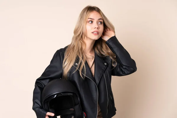 오토바이 헬멧을 러시아 소녀는 베이지 배경에서 무언가를 — 스톡 사진