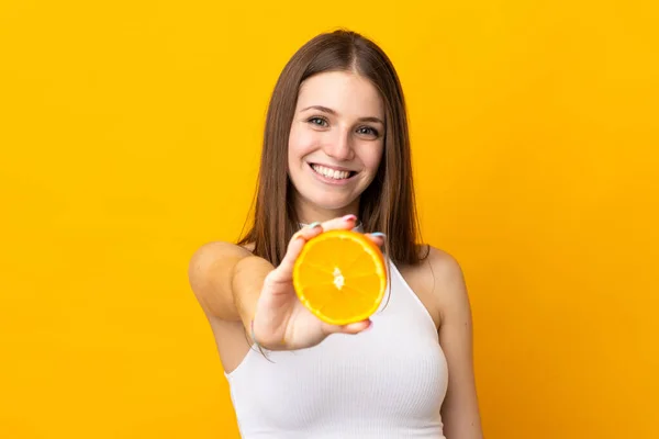 Joven Mujer Caucásica Sosteniendo Una Naranja Aislada Sobre Fondo Naranja —  Fotos de Stock