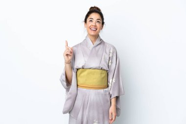 Kimono giymiş bir kadın izole edilmiş arka planda yukarı bakıyor ve şaşırıyor.