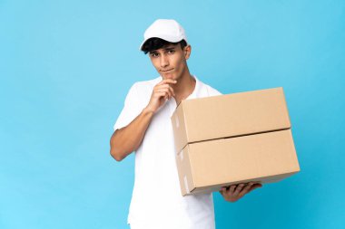 Arjantinli bir adam mavi arka planda izole edilmiş. Şüpheleri ve düşünceleri var.