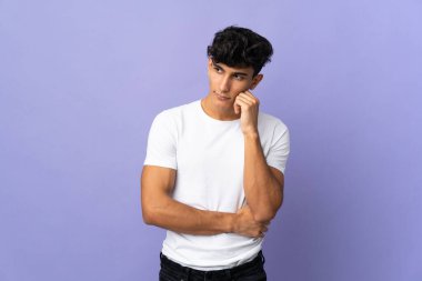 Arjantinli genç adam yorgun ve sıkılmış bir ifadeyle arka planda izole edilmiş.