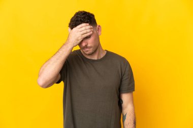 Sarı arka planda yalnız ve başı ağrıyan beyaz, yakışıklı bir genç.