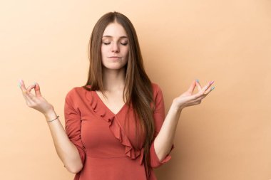 Zen pozunda bej arka planda izole edilmiş beyaz bir kadın.