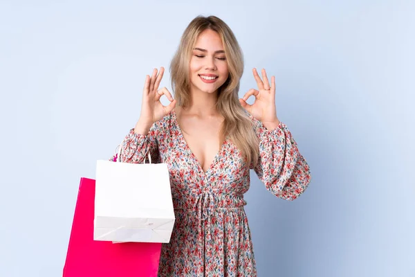 Alışveriş Çantalı Genç Rus Kız Zen Pozunda Mavi Arka Planda — Stok fotoğraf