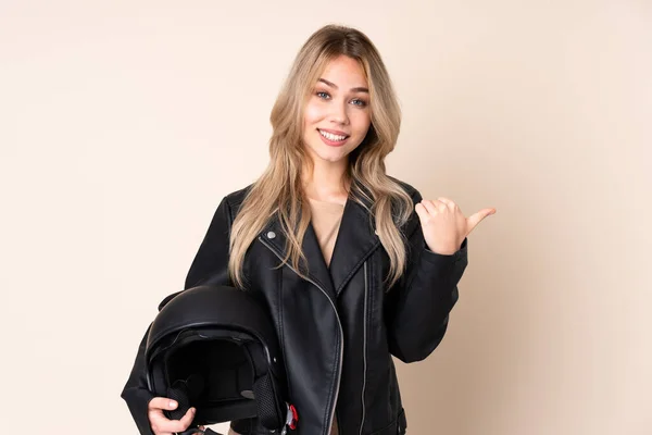ロシアの女の子とともにオートバイのヘルメットは 製品を提示する側を指してベージュの背景に隔離 — ストック写真