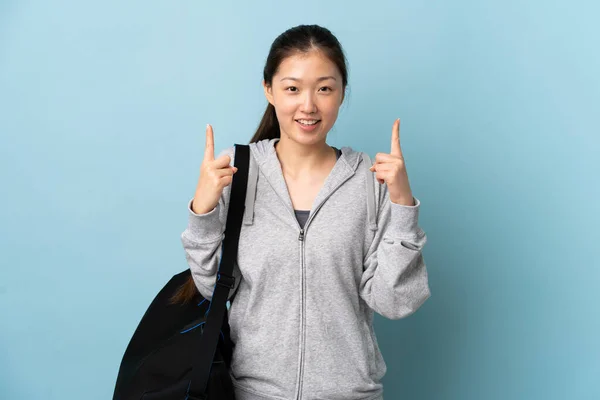 Jonge Sport Chinese Vrouw Met Sporttas Geïsoleerde Blauwe Achtergrond Wijzend — Stockfoto