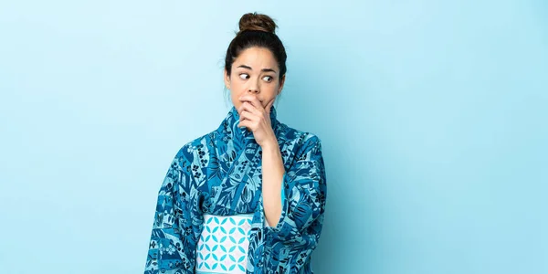 Mujer Vestida Con Kimono Sobre Fondo Aislado Que Tiene Dudas —  Fotos de Stock