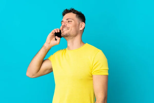 Young Caucasian Handsome Man Isolated Blue Background Keeping Conversation Mobile — Stock Photo, Image