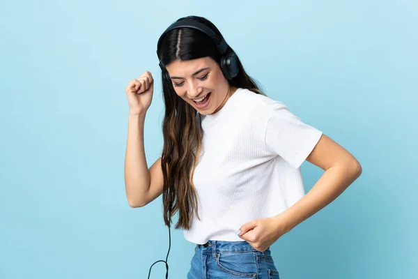 Joven Morena Sobre Fondo Azul Aislado Escuchando Música Bailando — Foto de Stock