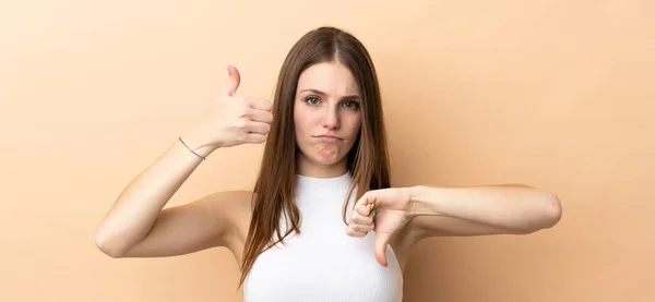 Young Caucasian Woman Isolated Beige Background Making Good Bad Sign — Stock Photo, Image