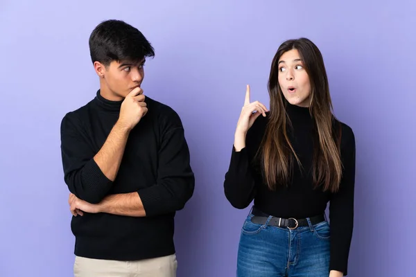 Young Couple Isolated Purple Background Standing Thinking Idea — Stock Photo, Image