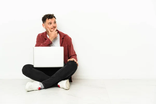 Jovem Bonito Homem Caucasiano Sit Chão Com Laptop Com Dúvidas — Fotografia de Stock