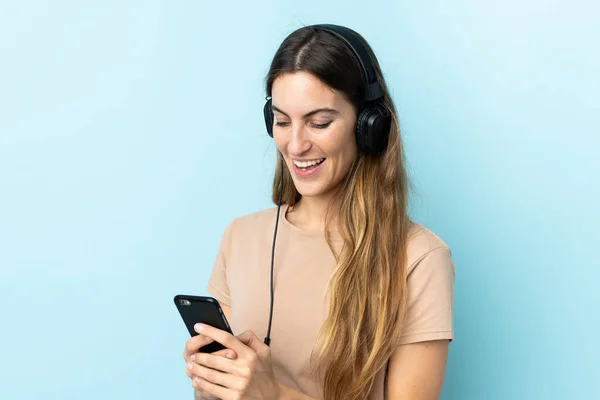 Young Caucasian Woman Isolated Pink Background Listening Music Looking Mobile — Stock Photo, Image