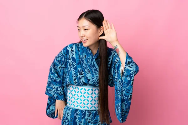 Joven Chica China Usando Kimono Sobre Fondo Aislado Escuchando Algo —  Fotos de Stock