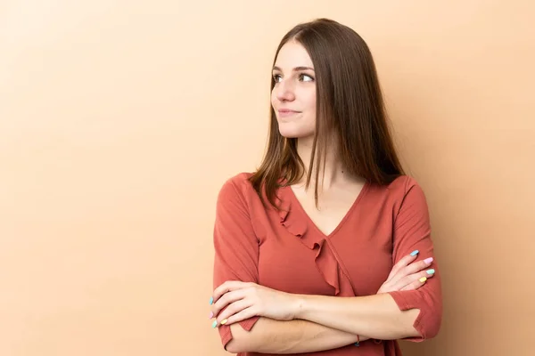 Giovane Donna Caucasica Isolata Sfondo Beige Guardando Lato — Foto Stock