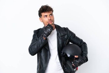 Motosiklet kasklı genç, beyaz arka planda izole edilmiş beyaz bir adam şüpheleri var.
