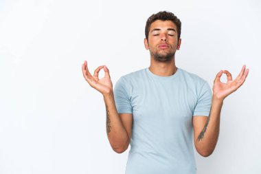 Genç ve yakışıklı Brezilyalı bir adam Zen pozunda beyaz arka planda izole edilmiş.