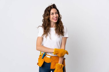 Genç elektrikçi beyaz arka planda izole edilmiş gülümserken yukarı bakıyor.