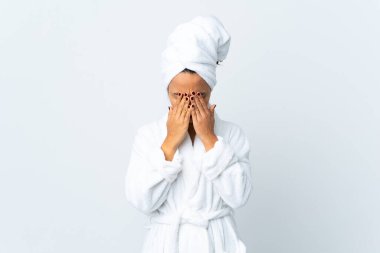 Bornozlu genç bir kadın soyutlanmış beyaz bir altyapısı var, yorgun ve hasta bir yüzü var.