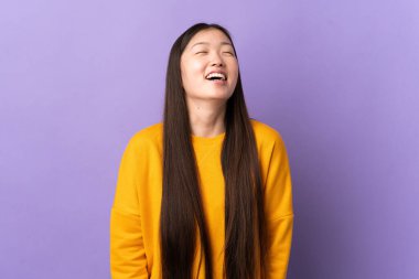 Mor arka planda yaşayan genç Çinli kız gülüyor.