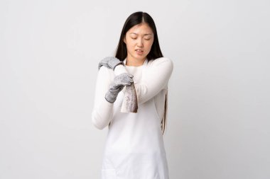 Çinli balıkçı önlük takıyor ve çırpındığı için omuz ağrısından muzdarip beyaz arka planda çiğ balık tutuyor.