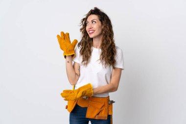 Genç elektrikçi beyaz arka planda izole edilmiş ve davet edilmek için ellerini yana uzatıyor.