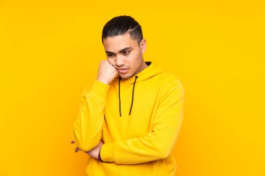 Asyalı yakışıklı adam sarı arka planda izole edilmiş, parmaklarıyla sekizi sayıyor.