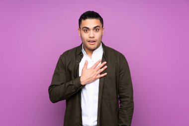 Asyalı yakışıklı adam mavi arka planda izole edilmiş, şaşırmış ve şaşırmış.