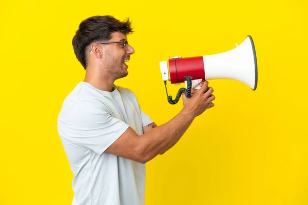 Jovem Caucasiano Bonito Homem Isolado Fundo Amarelo Gritando Através Megafone — Fotografia de Stock