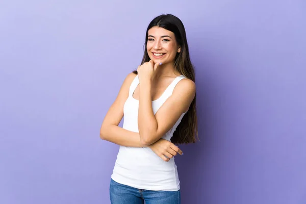 Young brunette woman over isolated purple background happy and smiling