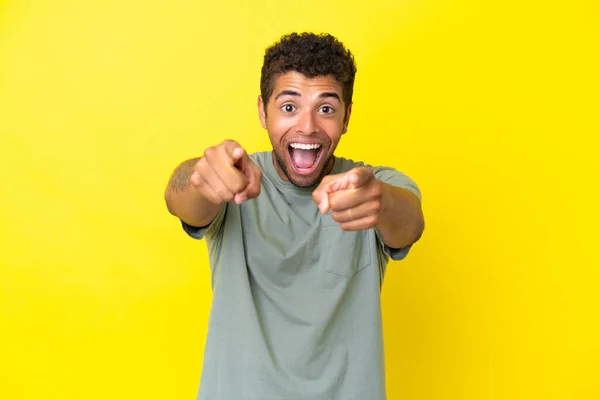 Joven Guapo Brasileño Aislado Sobre Fondo Amarillo Sorprendido Apuntando Frente —  Fotos de Stock