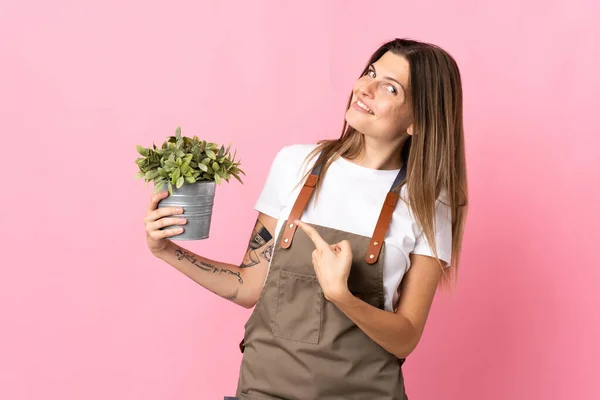 Tuinier Vrouw Houden Van Een Plant Geïsoleerd Roze Achtergrond Wijzend — Stockfoto