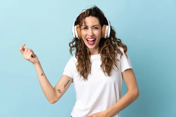 Joven Mujer Caucásica Aislada Sobre Fondo Azul Escuchando Música Haciendo —  Fotos de Stock