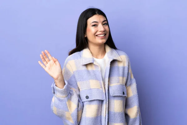 Giovane Donna Bruna Sfondo Viola Isolato Che Saluta Con Mano — Foto Stock