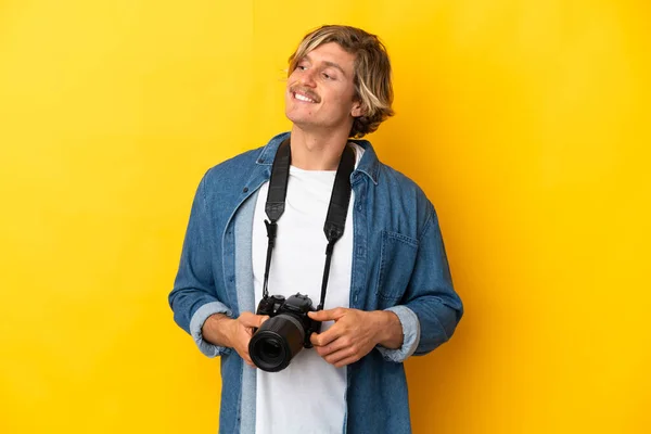 Jonge Fotograaf Man Geïsoleerd Gele Achtergrond Kijken Naar Zijkant Glimlachen — Stockfoto