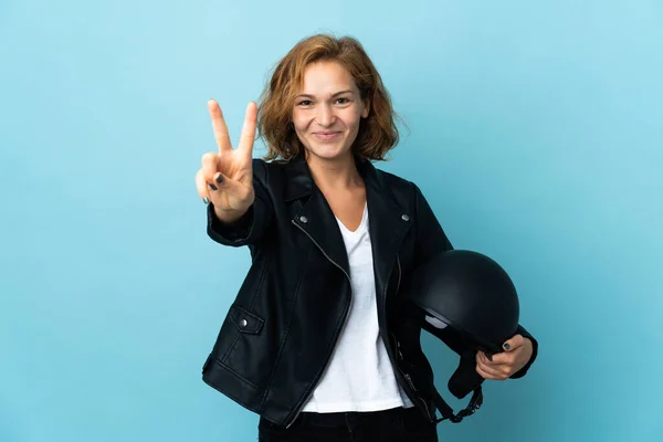 Chica Georgiana Sosteniendo Casco Motocicleta Aislado Sobre Fondo Azul Sonriendo —  Fotos de Stock