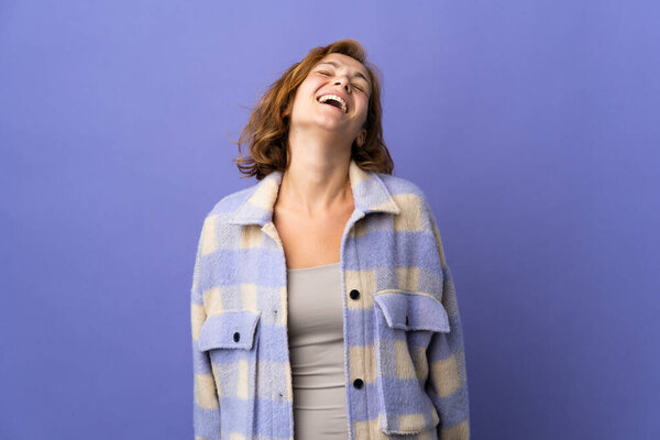 Молодая грузинка, изолированная на фиолетовом фоне смеется