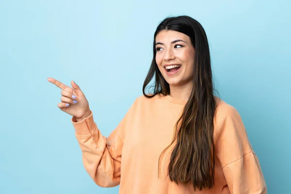 Joven Morena Sobre Fondo Azul Aislado Apuntando Con Dedo Hacia —  Fotos de Stock