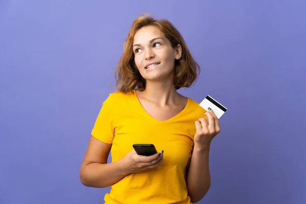 Jonge Georgische Vrouw Geïsoleerd Paarse Achtergrond Kopen Met Mobiele Telefoon — Stockfoto