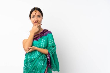 Beyaz arka planda izole edilmiş genç Hintli kadının şüpheleri var.