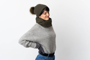 Kış şapkalı genç kız gayret gösterdiği için sırt ağrısı çekiyor.