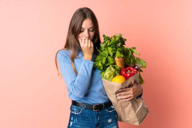 Elinde alışveriş çantası tutan Litvanyalı genç bir kadının şüpheleri var.