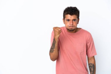 Genç ve yakışıklı Brezilyalı bir adam mutsuz bir ifadeyle beyaz arka planda izole edilmiş.