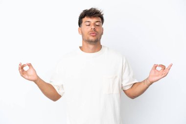 Beyaz arka planda Zen pozisyonunda beyaz tenli yakışıklı bir adam.