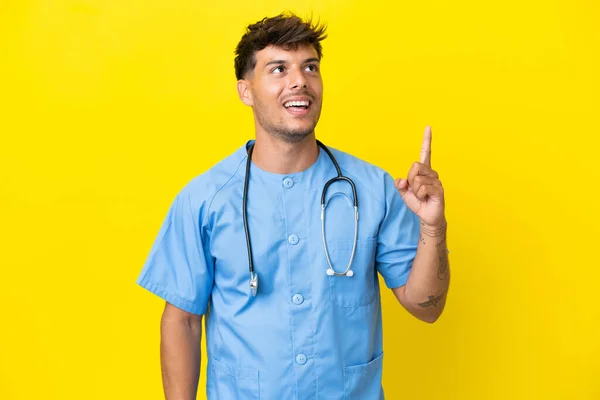 Giovane Medico Chirurgo Uomo Isolato Sfondo Giallo Che Punta Alto — Foto Stock