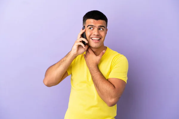 Joven Hombre Guapo Usando Teléfono Móvil Sobre Fondo Púrpura Aislado —  Fotos de Stock
