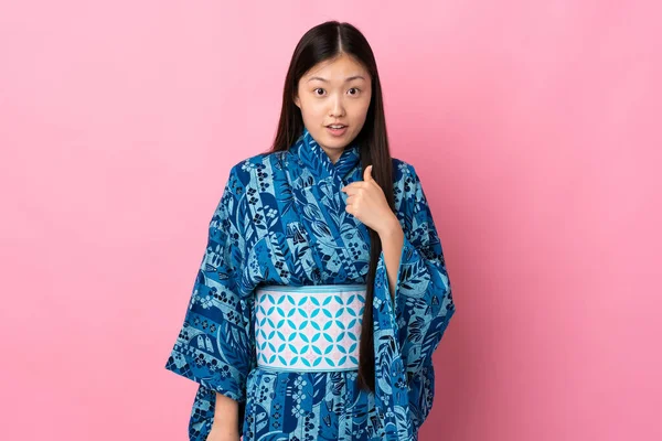 Junge Chinesin Trägt Kimono Über Isoliertem Hintergrund Und Zeigt Auf — Stockfoto