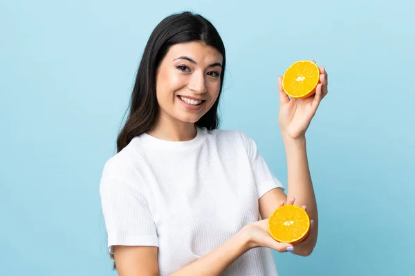 Ung Brunett Flicka Över Isolerad Blå Bakgrund Håller Orange — Stockfoto