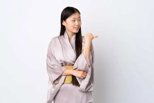 Joven Chica China Usando Kimono Sobre Fondo Aislado Apuntando Lado —  Fotos de Stock